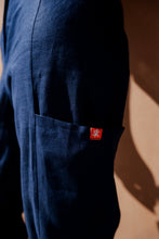 Load image into Gallery viewer, Detailed shot of the pocket on Sofa Killer dark blue linen trousers Lucia, featuring the signature SK tag.