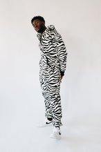 Load image into Gallery viewer, Stylish Sofa Killer animal men onesie Zebra design worn by a man standing against a plain background.