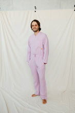 Load image into Gallery viewer, Smiling man in Sofa Killer violet color linen onesie, hands tucked in pockets, posing confidently on a neutral background. Ideal for casual summer wear.