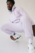 Load image into Gallery viewer, Sofa Killer men hoodie Medusa featured on a model in stylish light violet loungewear, squatting with a relaxed pose and wearing white sneakers.