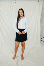 Load image into Gallery viewer, Model wearing a natural white linen crop top JARAN, standing barefoot and showing off the relaxed style with a skirt.