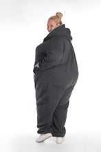 Load image into Gallery viewer, Sofa Killer dark grey plus size adult onesie featuring light grey cuffs, shown from the side, highlighting its cozy fit and pockets.