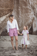 Load image into Gallery viewer, A mother and daughter walking hand in hand on the beach, the daughter wearing a Sofa Killer linen beige dress with violet color details, highlighting a sweet family moment.