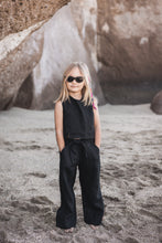 Load image into Gallery viewer, Sofa Killer linen black girl set featuring a young girl in stylish black top and pants, standing confidently on the beach with sunglasses.