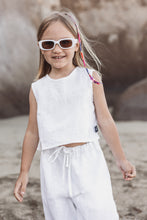 Load image into Gallery viewer, Sofa Killer linen white girl set showcasing a smiling girl in a white linen outfit, complete with sunglasses, enjoying a sunny day at the beach.