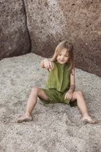 Load image into Gallery viewer, A young girl playing in sand while wearing the Sofa Killer linen moss green unisex set with shorts, showcasing comfort and style for special occasions.