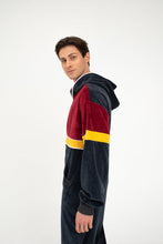 Load image into Gallery viewer, Sofa Killer velour onesie Kansas worn by a man, featuring a stylish dark grey, red, and yellow design, perfect for cozy days.