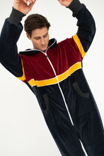 Load image into Gallery viewer, Close-up of a man raising his arms while wearing the Sofa Killer velour onesie Kansas, highlighting the soft velour texture and colorful design.