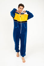 Load image into Gallery viewer, Model in Sofa Killer men velour onesie Dakota, demonstrating a relaxed look with vibrant colors, perfect for cozy days.
