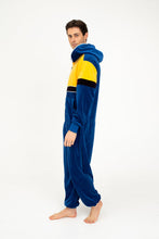 Load image into Gallery viewer, Sofa Killer men velour onesie Dakota in royal blue and yellow, modeled by a man standing sideways, showcasing its soft texture and comfortable fit.