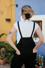 Load image into Gallery viewer, Back view of a woman in the 'Linen black color jumpsuit with adjustable straps Paloma', highlighting the adjustable straps and wide-leg design.
