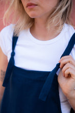 Load image into Gallery viewer, Focus on the adjustable straps of the Linen dark blue color jumpsuit with adjustable straps Paloma, with the model's casual outfit layered over a white tee.
