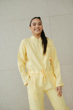 Load image into Gallery viewer, Model smiling while wearing a Sofa Killer lime yellow linen women onesie, showcasing its stylish design and comfortable fit.
