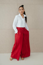 Load image into Gallery viewer, Sofa Killer red linen trousers Doha modeled with a white crop shirt, showcasing a relaxed and stylish look.
