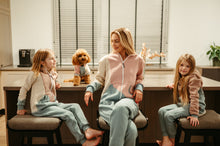 Load image into Gallery viewer, A dog onesie style vintage displayed as a mother and her two daughters smile in coordinating outfits, capturing a playful family moment with their adorable dog.
