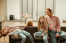 Load image into Gallery viewer, Casual family scene featuring a dog onesie style vintage, with a woman and her two girls lounging comfortably, highlighting the stylish and cozy loungewear.
