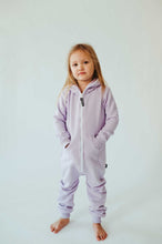 Load image into Gallery viewer, Sofa Killer unisex kids onesie Medusa featuring light purple color; a child poses with a serious expression, highlighting the cozy look and relaxed fit of the jumpsuit.
