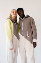Load image into Gallery viewer, Close-up of two models in the Sofa Killer tricolor onesie Breeze, showcasing vibrant colors and cozy fit.
