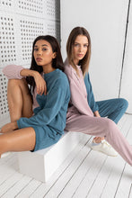 Load image into Gallery viewer, Two models wearing Sofa Killer's two color women lounge wear with shorts option in pink and blue, showcasing stylish and comfortable loungewear. One model is seated in a shorts set while the other sports a pants set, both exuding a casual and trendy vibe.
