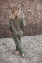 Load image into Gallery viewer, Back view of a unisex kids onesie by Sofa Killer in dark green, showcasing the comfortable design as a child walks on sandy terrain.
