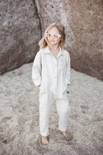 Load image into Gallery viewer, Sofa Killer linen beige unisex kids onesie featuring a child standing on the beach, highlighting the comfy design and trendy style.
