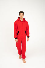 Load image into Gallery viewer, Sofa Killer red onesie Texas with black zipper, featuring a model walking in a cozy outfit with a hood.
